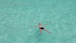 Teenager has a rest on turquoise transparent water of ocean