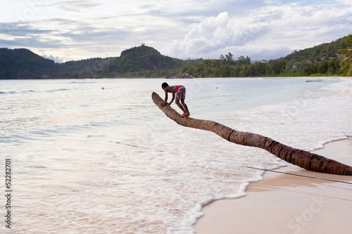 Photo: enfant sur tronc de cocotier enfant sur tronc de cocotier