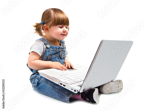Photo: Cute little girl sitting with a laptop Cute little girl sitting with a laptop