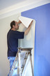 man putting up wallpaper