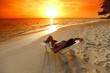Photo: Woman in chaise-lounge relaxing on beach Woman in chaise-lounge relaxing on beach