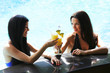 Photo: Two women with cocktails in swimming pool Two women with cocktails in swimming pool