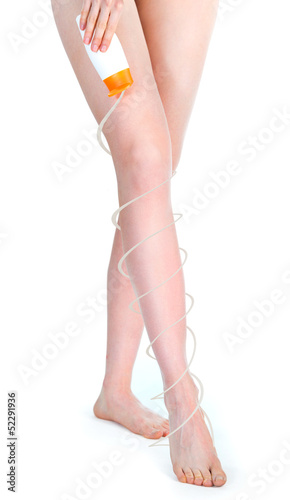 Photo: Woman putting lotion on legs Woman putting lotion on legs