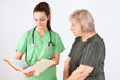 Photo: Nurse and senior reading medical file Nurse and senior reading medical file