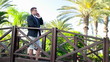 Young businessman talking on cellphone in exotic resort