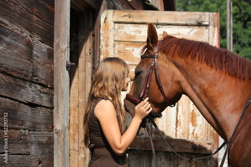 Photo: Portrait of teenage girl and chestnut horse near the wooden stab Portrait of teenage girl and chestnut horse near the wooden stab