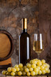 White wine, grapes, old bottle and a barrel.