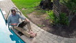 Video: Happy man watching movie on laptop by the pool Happy man watching movie on laptop by the pool