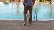 Happy young man stretching and relaxing by the swimming pool
