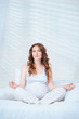 Pregnant woman sit on bed