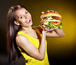 Woman holding hamburger.