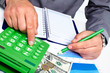 Hand with calculator and money.
