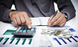 Hand with calculator and money.