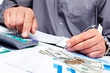 Hand with calculator and money.