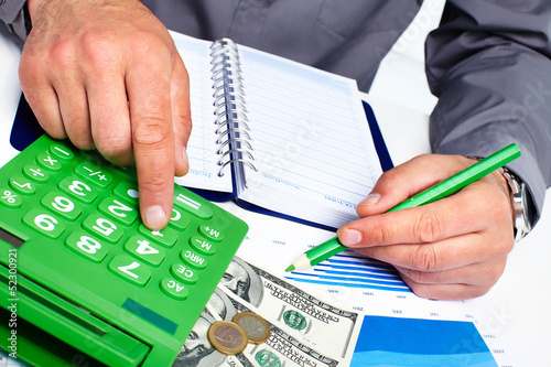 Photo: Hand with calculator and money. Hand with calculator and money.