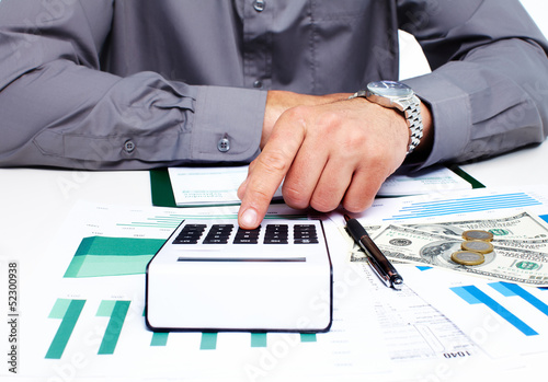 Photo: Hand with calculator and money. Hand with calculator and money.