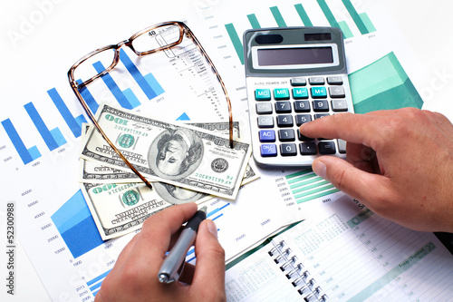 Photo: Hand with calculator and money. Hand with calculator and money.