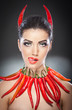 beautiful young woman portrait with red hot and spicy peppers
