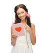 young woman holding flower and postcard