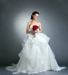 Foto: Charming bride with bouquet posing in studio Charming bride with bouquet posing in studio