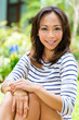 Foto: Young Asian woman at home in garden reading Young Asian woman at home in garden reading