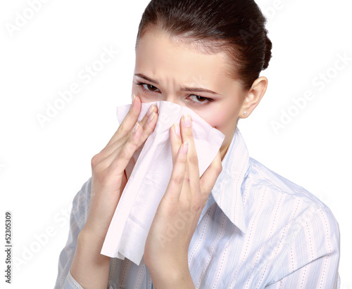 Photo: A portrait of a young woman blowing her nose A portrait of a young woman blowing her nose