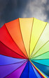 Rainbow umbrella on stormy sky background