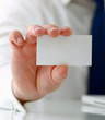 Man's hand holding blank white business card