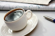 cup near newspapers