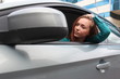 Woman in a car, looking into car side mirror