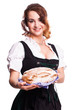 junge Frau im Dirndl bietet ein Brot an