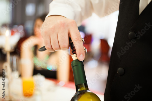 Photo: Waiter uncorking a wine bottle Waiter uncorking a wine bottle