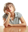 Photo: A young frightened woman sitting at the desk A young frightened woman sitting at the desk
