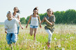 Friends running in meadow