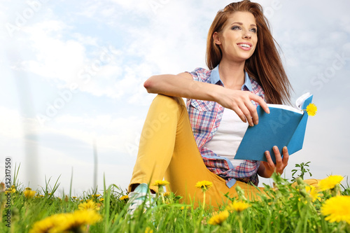 Photo: beautiful girl with book on grass beautiful girl with book on grass
