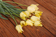 Bouquet of yellow tulips on a brown wooden board