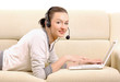 Young woman lying on sofa with laptop