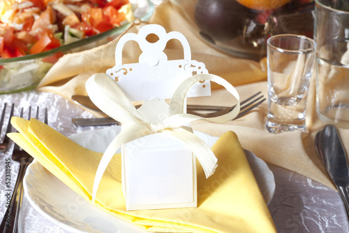 Photo: Wedding table cutlery and gift box on plate background concept Wedding table cutlery and gift box on plate background concept