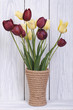 Bouquet of different color tulips in a vase on a wooden
