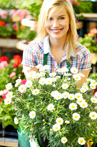 Photo: Florists woman working with flowers at a greenhouse. Florists woman working with flowers at a greenhouse.