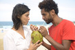 Photo: Multiethnic couple drinking coconut water Multiethnic couple drinking coconut water