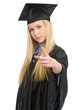 Concerned young woman in graduation gown threatening with finger