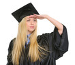 Young woman in graduation gown looking into distance