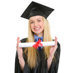 Smiling young woman in graduation gown showing diploma