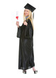 Full length portrait of woman in graduation gown showing diploma