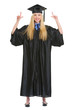 Happy young woman in graduation gown pointing up