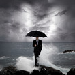 Business man under an umbrella in the sea