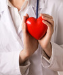 Female doctor with stethoscope holding heart