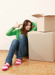 Young woman sitting on the floor near boxes