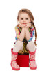 little girl sitting on the cube, isolated